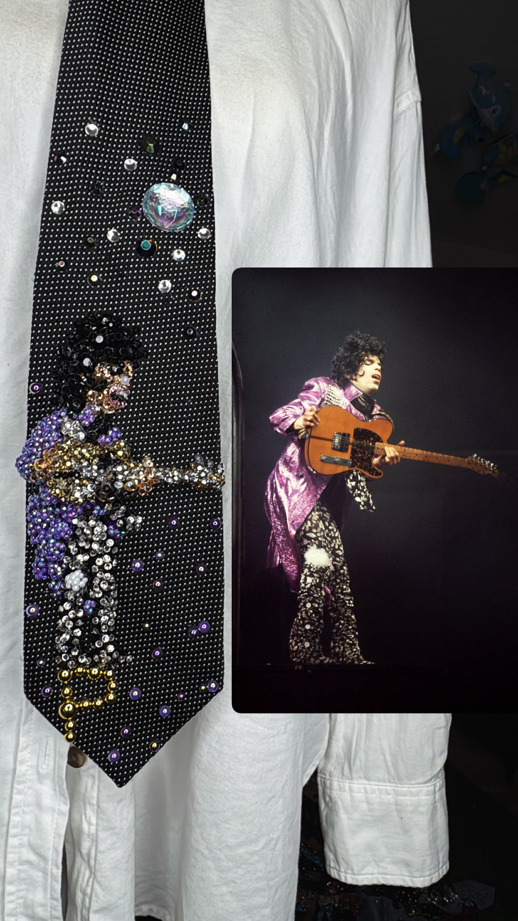 Black Prince Holding Guitar Sideways Dramatically While Performing Live in Purple Trench and Black Pants