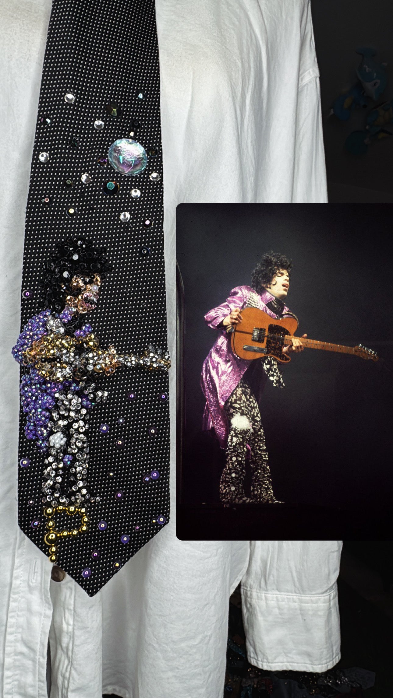 Black Prince Holding Guitar Sideways Dramatically While Performing Live in Purple Trench and Black Pants